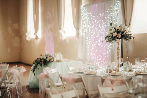 a room with tables and chairs with flowers on them at UKI Puhkeküla in Ranna