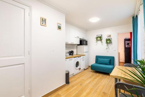 un salon avec une chaise bleue et une cuisine dans l'établissement GuestReady - Bel appartement cosy dans le 3e arr., à Paris