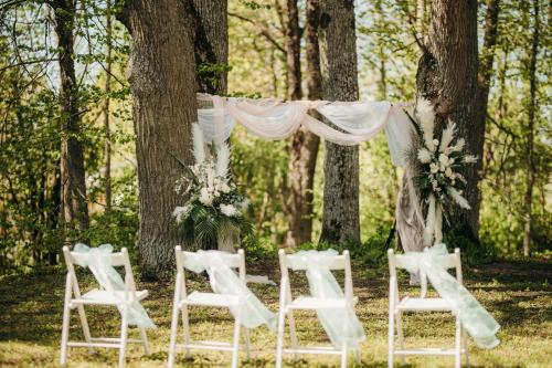 a row of white chairs and a altar with flowers at UKI Puhkeküla in Ranna