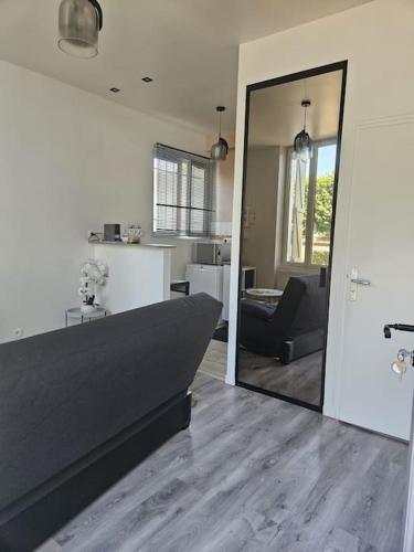 a living room with a couch and a mirror at Beautiful F2 apartment 5 stops by train from Paris in Moret-sur-Loing