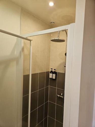 a bathroom with a shower with a glass door at Beautiful F2 apartment 5 stops by train from Paris in Moret-sur-Loing