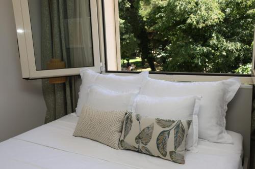 a bed with white pillows sitting in front of a window at Makarska City Bay Studios in Makarska