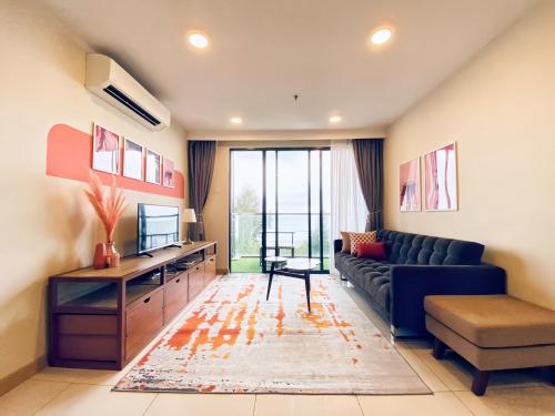 a living room with a couch and a tv at TimurBay Seafront Residence Kuantan in Kuantan