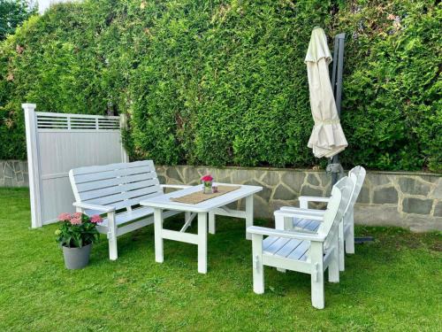 a table and two chairs and an umbrella on the grass at Down town apartment with outside area in villa in Kristiansand