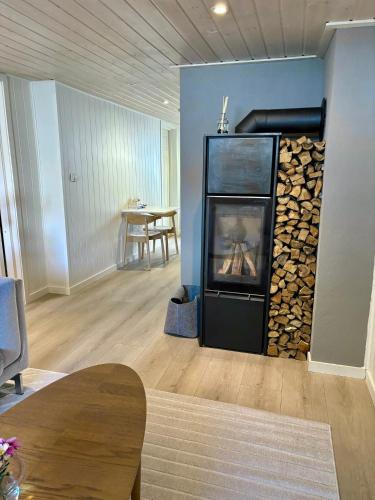 a living room with a fireplace with a pile of fire wood at Down town apartment with outside area in villa in Kristiansand