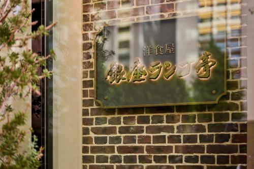 a sign on the side of a brick wall at The Royal Park Hotel Ginza 6-Chome in Tokyo
