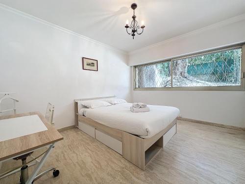 une chambre avec un lit, un bureau et une fenêtre dans l'établissement 130m2 Terrasses, Jardin, 4chambres, Climatisation, à Cannes