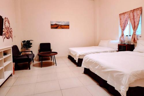 a hotel room with two beds and a chair at Rainbow Homestay in Green Island