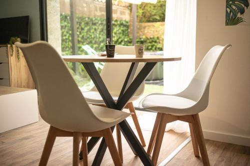 deux chaises blanches autour d'une table dans une cuisine dans l'établissement Cocon avec spa dans le centre, à Boulogne-sur-Mer