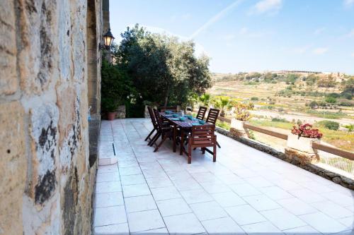 a table and chairs on a patio with a view at Villeleynah Amazing Gozitan Villa Pool - Happy Rentals in Munxar