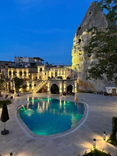a large swimming pool in front of a building at Göreme Cave Suites in Goreme