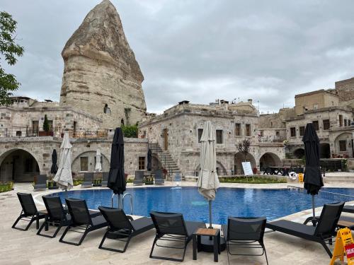 a group of chairs and umbrellas next to a pool at Göreme Cave Suites in Goreme