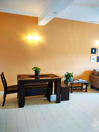 a living room with a table and a chair at Cozy & Comfy 3 rooms apartment near beach in Batu Ferringhi