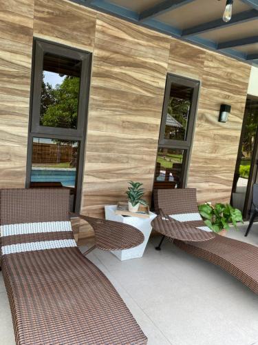 a patio with two chairs and a table and two windows at RedBeach House Private BEACH HOUSE with Pool Real Quezon in Real