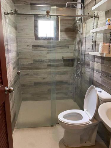 a bathroom with a shower with a toilet and a sink at RedBeach House Private BEACH HOUSE with Pool Real Quezon in Real