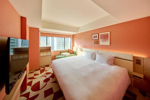 a hotel room with a large bed and a window at The Royal Park Hotel Ginza 6-Chome in Tokyo