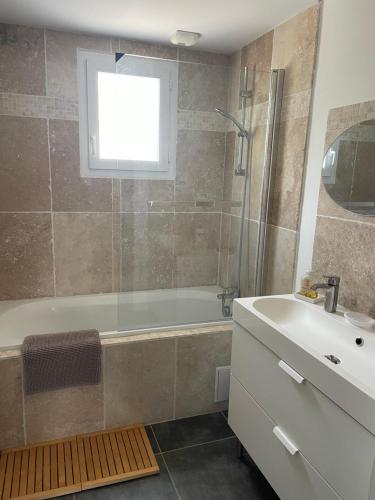 une salle de bain avec une baignoire et un lavabo dans l'établissement Villa les hortensias, à Vaucelles