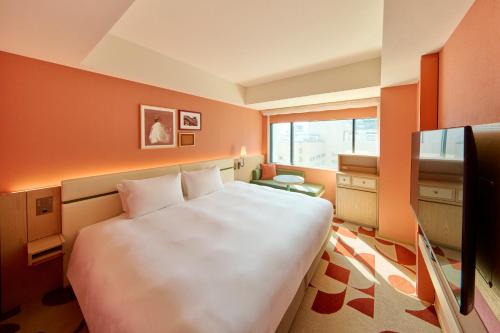 a bedroom with a large white bed and a window at The Royal Park Hotel Ginza 6-Chome in Tokyo