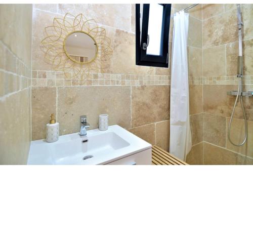 une salle de bain avec un lavabo et une douche avec un miroir dans l'établissement Jolie villa avec piscine sans vis a vis, à Bezouce