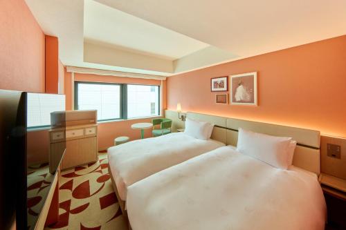 a hotel room with two beds and a desk at The Royal Park Hotel Ginza 6-Chome in Tokyo