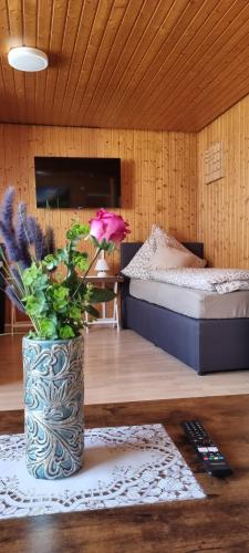 a room with a bed and a vase with a flower at City Apartment Triberg in Triberg