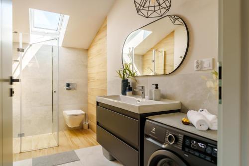 a bathroom with a sink and a mirror at Apartamenty Lighthouse - Premium Dźwirzyno in Dźwirzyno