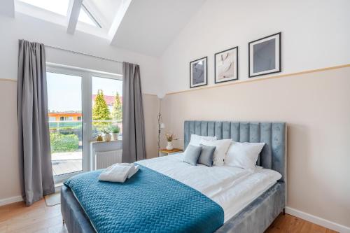 a bedroom with a large bed with a large window at Apartamenty Lighthouse - Premium Dźwirzyno in Dźwirzyno