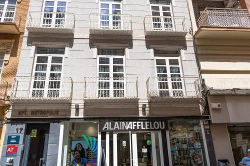 een winkel voor een gebouw met ramen bij Apartamentos Turísticos Metropolis in Cartagena