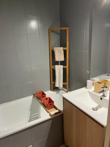 une salle de bain avec un lavabo, une baignoire et un miroir dans l'établissement T2 40m2 Rez-de-Jardin, bord de mer, Cavalaire-sur-Mer, à Cavalaire-sur-Mer