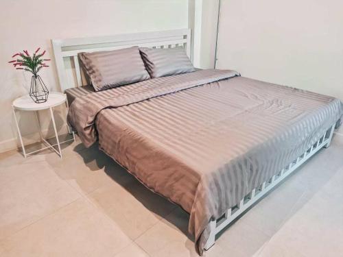 a large bed in a bedroom with a table at Jira19Hostel in Bangkok