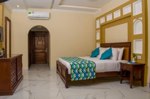 a bedroom with a bed with blue pillows at Cocoa Luxury Resort, Nyali, Mombasa in Mombasa