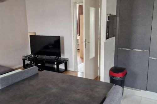 un salon avec un canapé et une télévision à écran plat dans l'établissement Refuge Urbain Chic avec Balcon, à Saint Lo