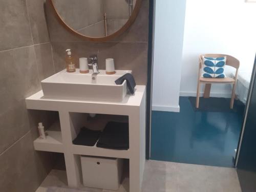 une salle de bain avec un lavabo blanc et un miroir dans l'établissement Havre de paix, à Rodez