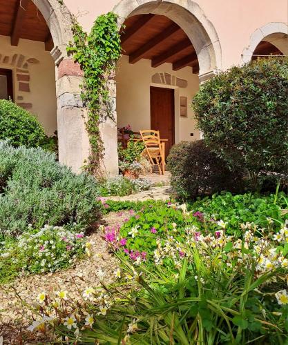 a garden with flowers in front of a house at B&B S'Omu Antiga in Nureci