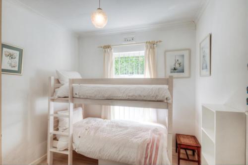 two bunk beds in a room with a window at Mermaid Rock Cottage in Cape Town