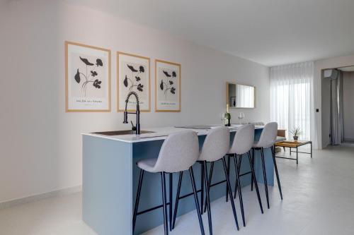 グジラにあるChic Penthouse Steps from the Promenadeのキッチン(スツールとカウンタートップ付きのバー付)