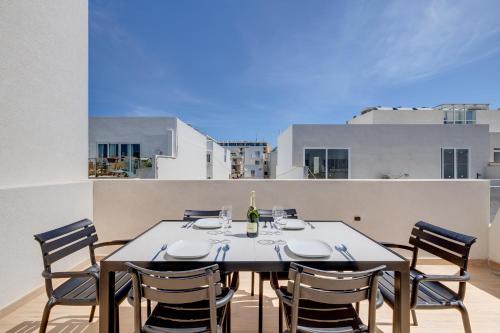 グジラにあるChic Penthouse Steps from the Promenadeのダイニングテーブル、バルコニー(椅子付)