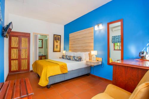 una camera con un letto con una parete blu di The Villa Manor & Spa a Bela-Bela