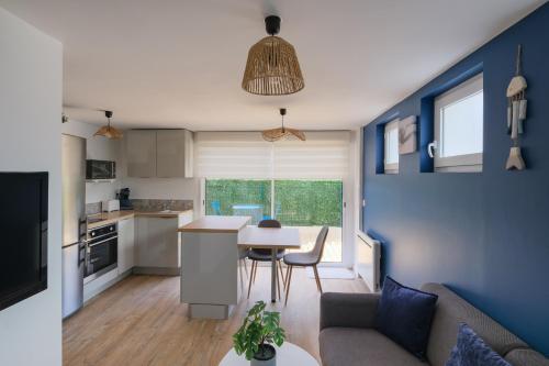 une cuisine et un salon avec un canapé et une table dans l'établissement La Maritime - Vue port, 50 m de la plage de la baie, à Saint-Nazaire