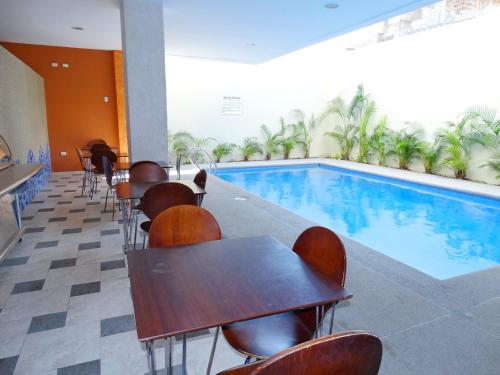 um restaurante com piscina, mesas e cadeiras em Hotel Marvento II em Salinas