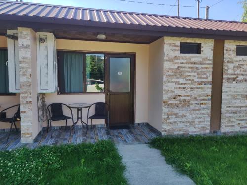 a house with a patio with a table and chairs at Ananuri Cottages in Ananuri