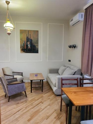 a living room with a couch and a table at Dat Exx Apartments On Liberty Square in Tbilisi City
