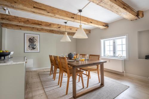 a kitchen and dining room with a wooden table and chairs at City Apartment With Exposed Ceiling Beams in Copenhagen