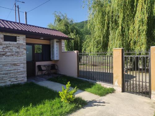 a fence in front of a house with a patio at Ananuri Cottages in Ananuri