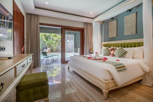 a bedroom with a large bed and a balcony at Sense Canggu Beach Hotel in Canggu