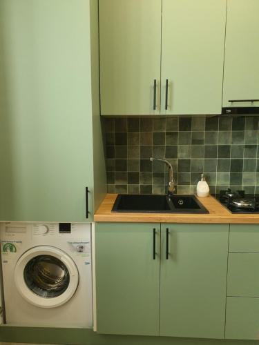 a kitchen with a washing machine and a sink at Dat Exx Apartments On Liberty Square in Tbilisi City