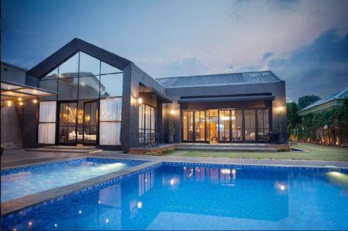 a house with a swimming pool in front of it at De Black Challet Villa in Tagalbato