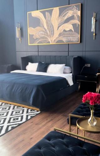 a bedroom with a large bed and a table at De Black Challet Villa in Tagalbato