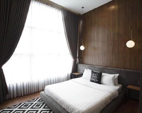 a bedroom with a bed and a large window at De Black Challet Villa in Tagalbato