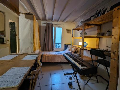 - une chambre avec un lit et un bureau avec un clavier dans l'établissement Loft authentique et bohème - Montorgueil, à Paris